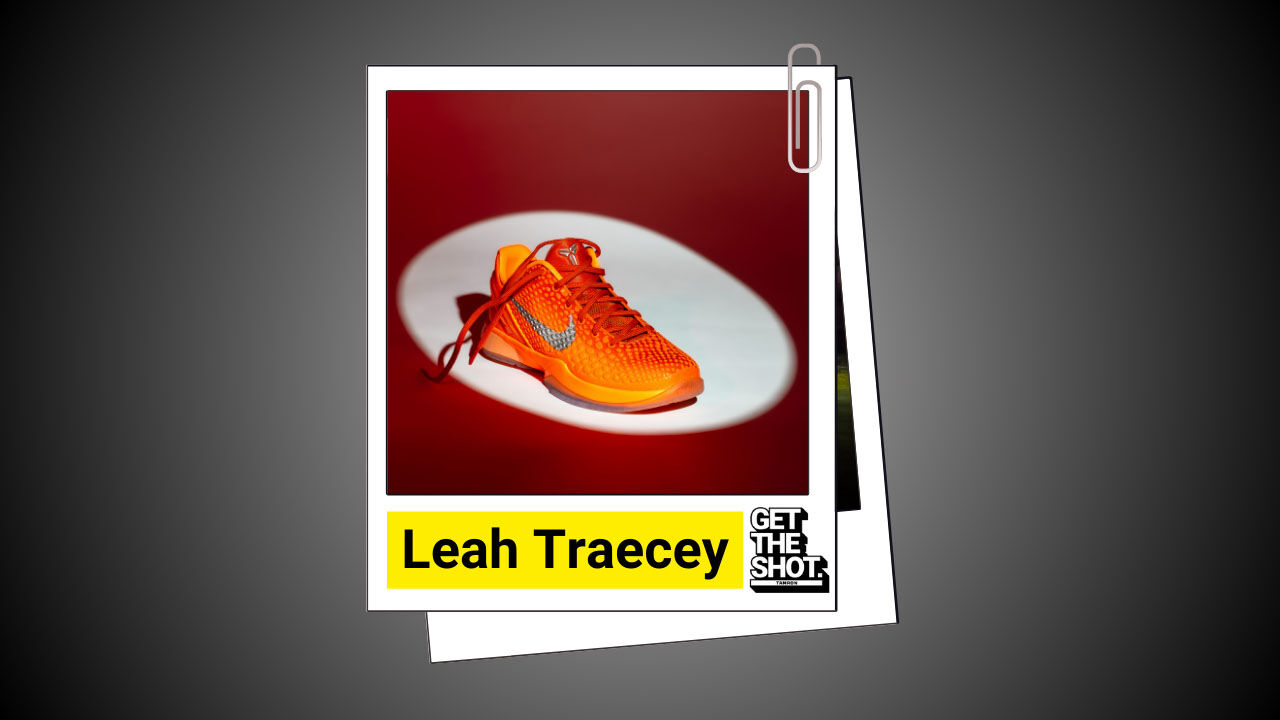 Bright orange Nike running shoe highlighted against a red backdrop.