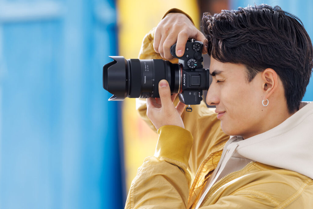 Photographer using Tamron 35-100mm F/2.8 lens for professional shots.
