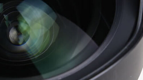 Tamron camera lens close-up Tamron camera lens with detailed glass elements and aperture.