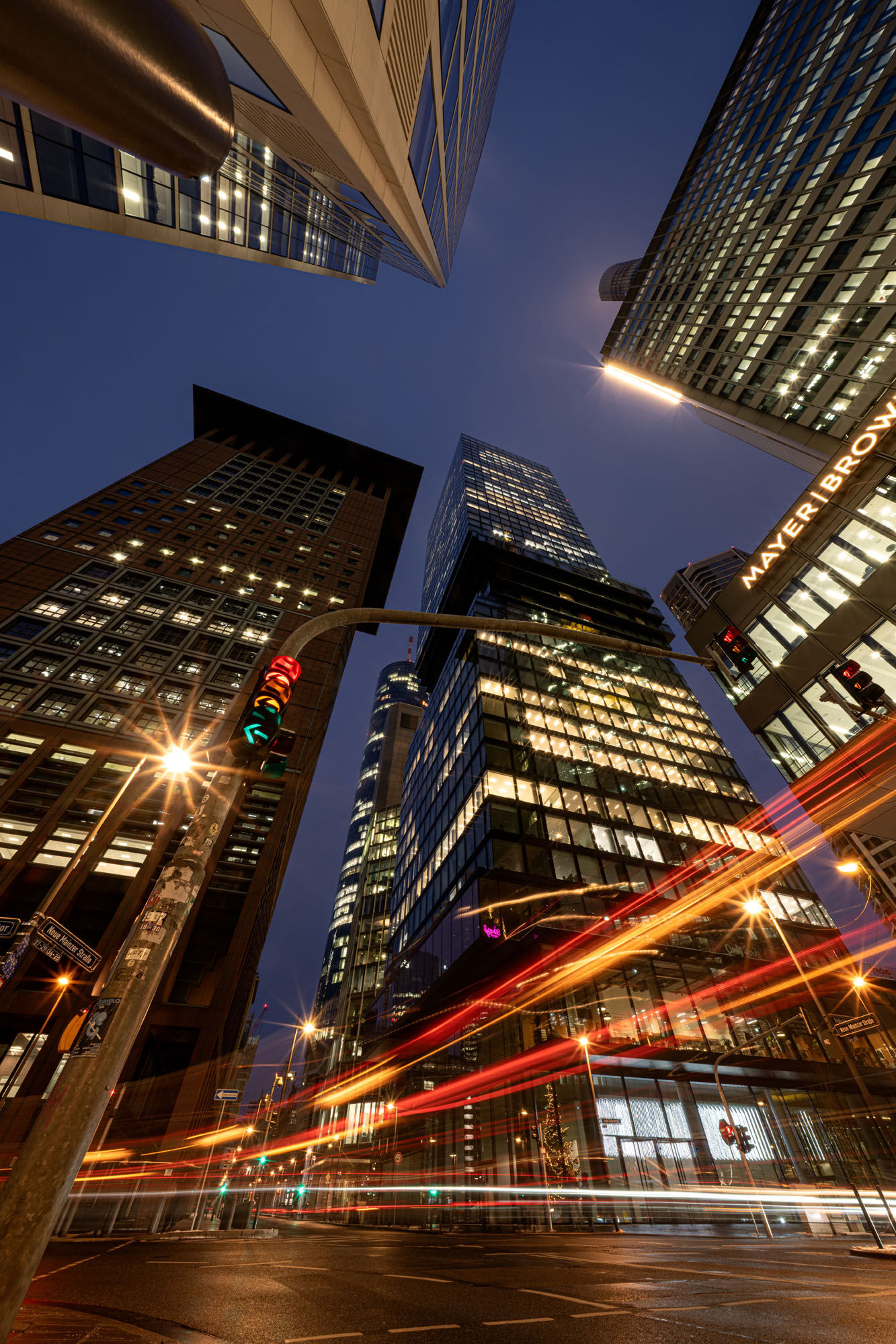 Urban cityscape featuring illuminated skyscrapers and busy streets at night, showcasing vibrant city.
