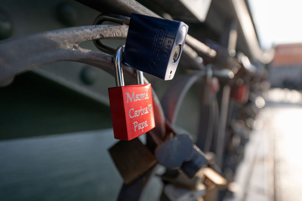 Lock on a bicycle lock with multiple padlocks attached.
