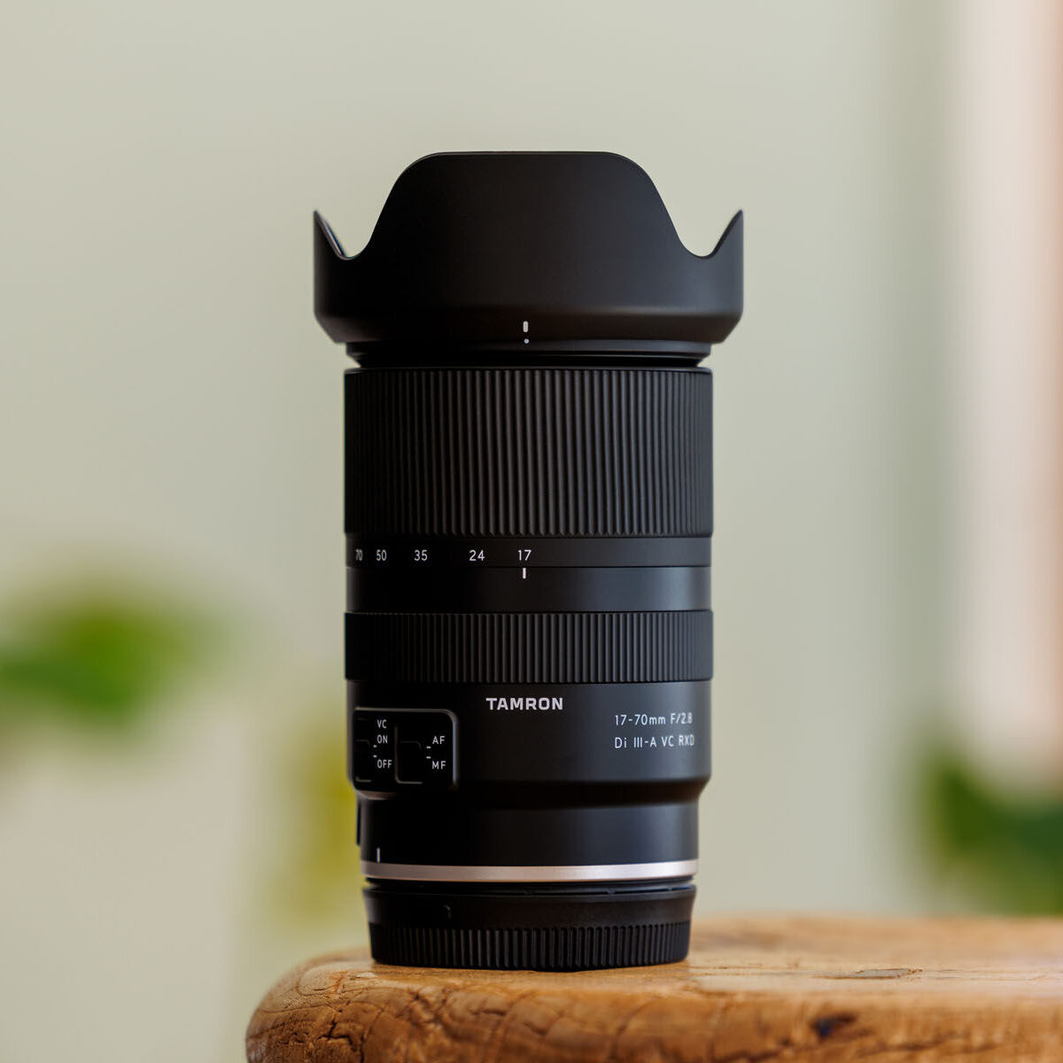Tamron lens on wooden surface with blurred background.