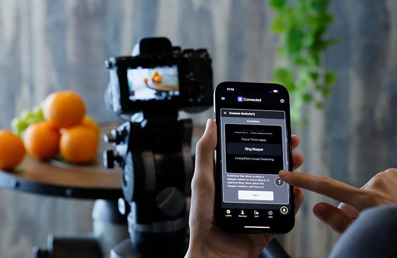 Using Tamron Lens for Smartphone Photography Person adjusting camera settings with Tamron lens on camera.
