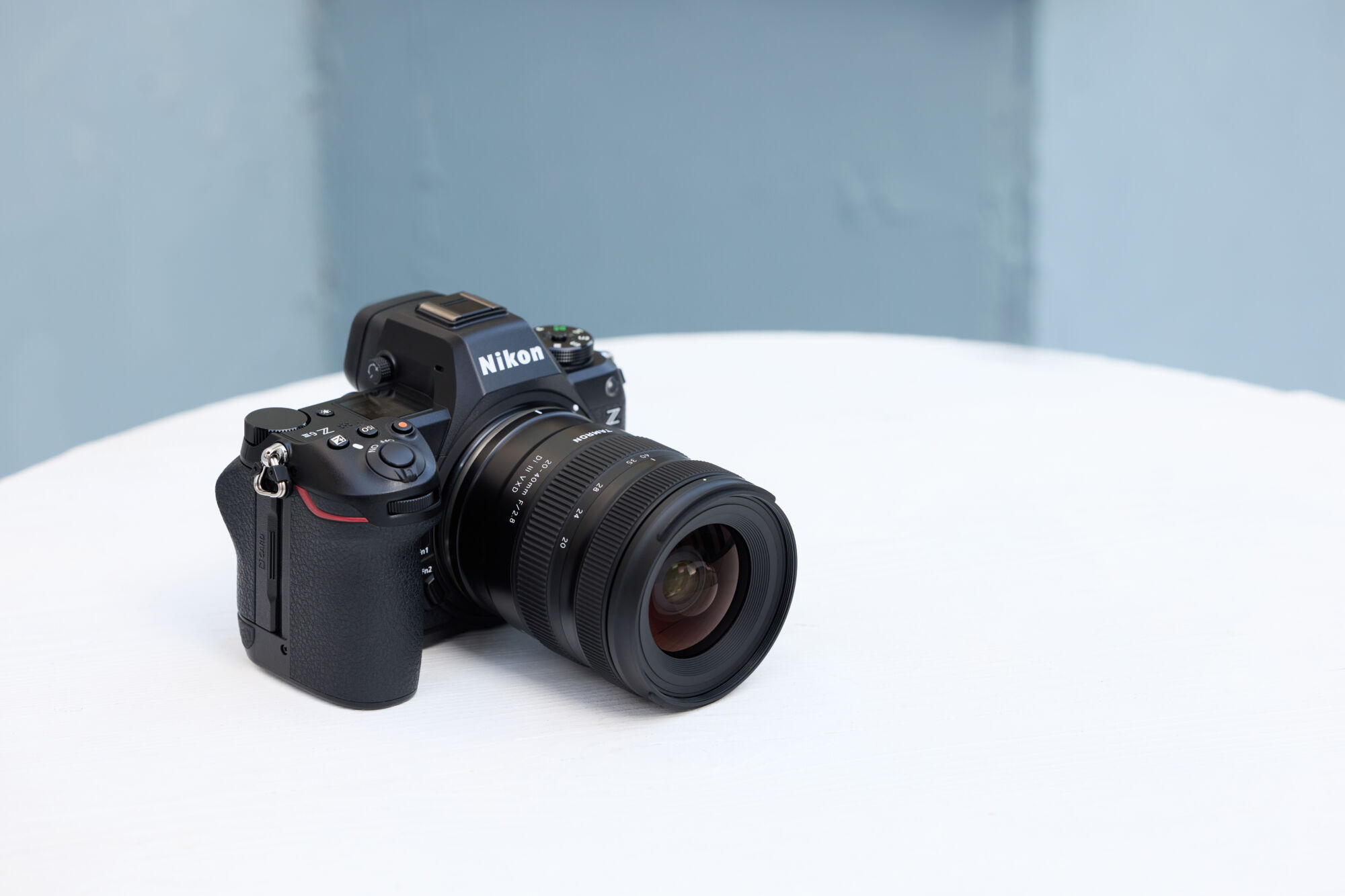 Nikon camera fitted with Tamron lens on a white surface.